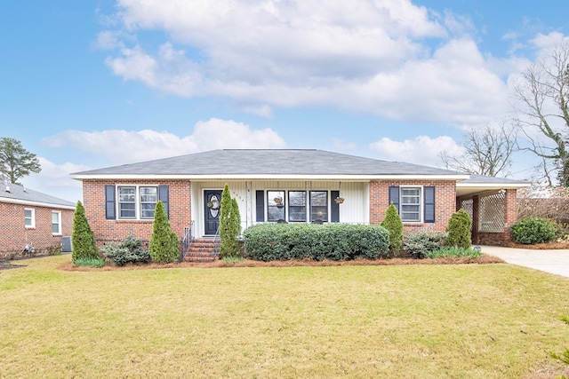 ranch-style home featuring driveway, an attached carport, central air condition unit, a front yard, and brick siding