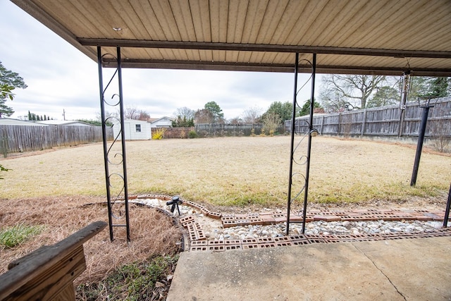 view of yard featuring an outbuilding, fence, and a storage unit