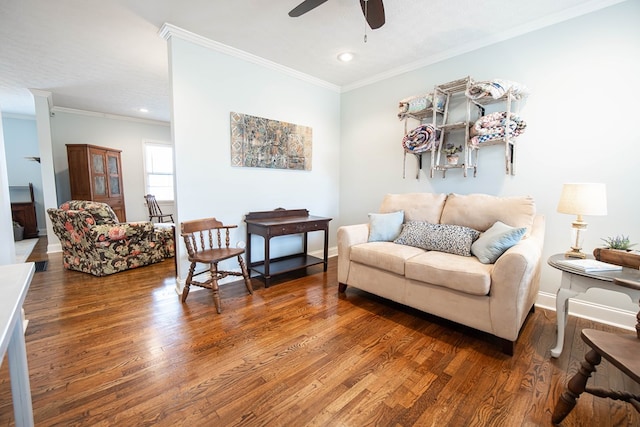 living room with ornamental molding, ceiling fan, baseboards, and wood finished floors