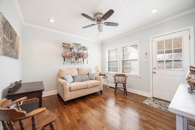 living room featuring a textured ceiling, ornamental molding, dark wood-style flooring, and baseboards