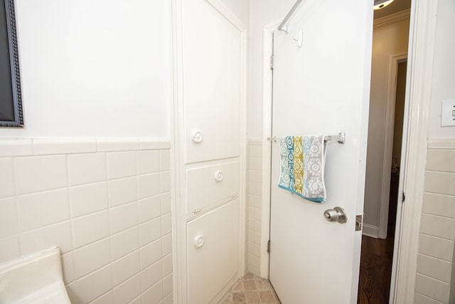 bathroom with wainscoting and tile walls