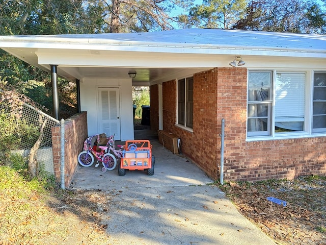 view of car parking with an attached carport, driveway, and fence