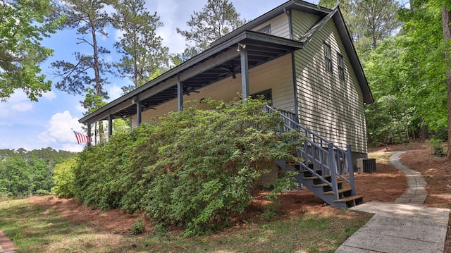 view of side of home featuring ceiling fan and central air condition unit