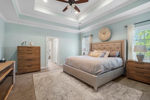 bedroom with carpet floors, multiple windows, a tray ceiling, and crown molding