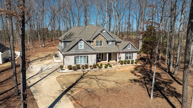 craftsman-style house featuring board and batten siding, concrete driveway, and a shingled roof