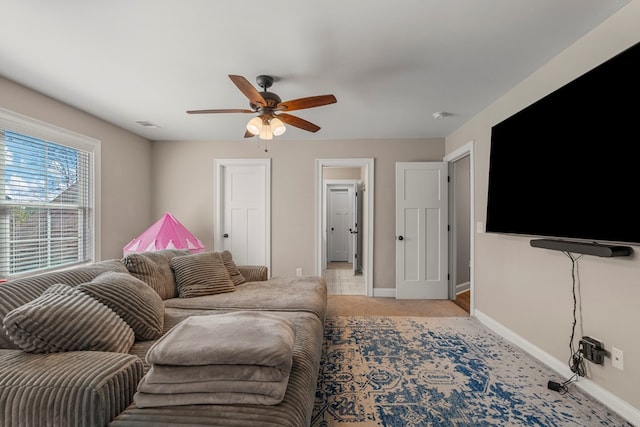 living room with light carpet, ceiling fan, visible vents, and baseboards