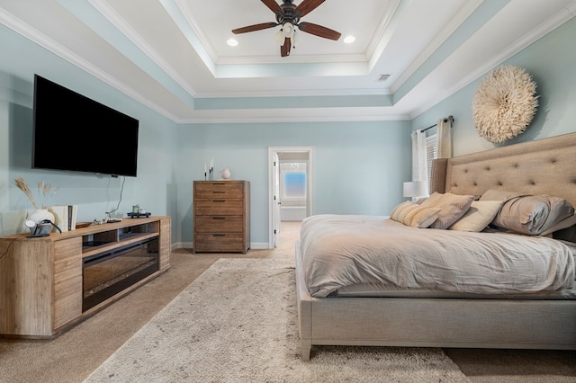 bedroom with light carpet, visible vents, baseboards, a tray ceiling, and crown molding