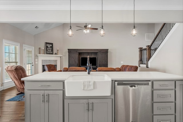 kitchen featuring a sink, open floor plan, stainless steel dishwasher, gray cabinets, and dark wood-style floors