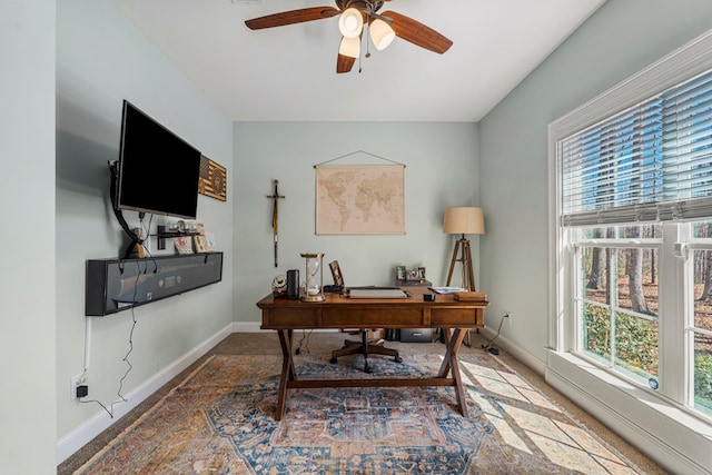 office space featuring ceiling fan and baseboards