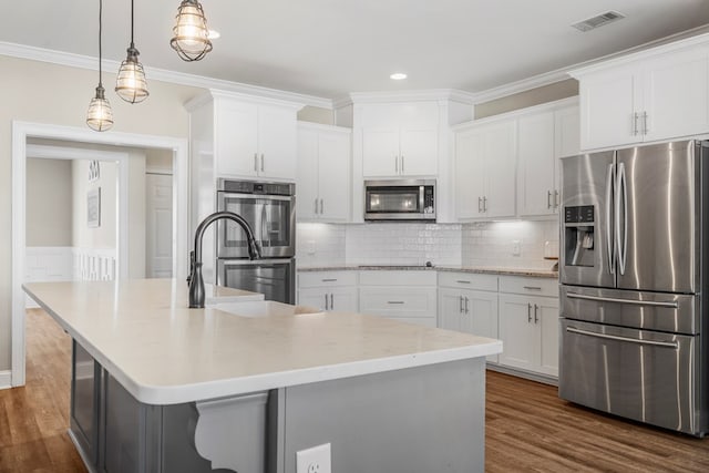 kitchen featuring white cabinets, visible vents, stainless steel appliances, and dark wood-type flooring