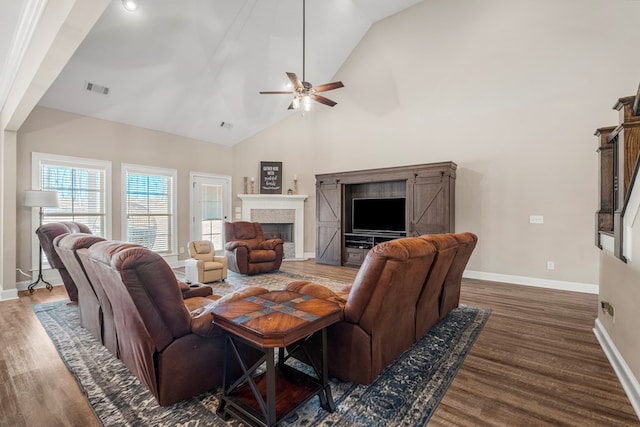 living area featuring high vaulted ceiling, a fireplace, wood finished floors, visible vents, and baseboards