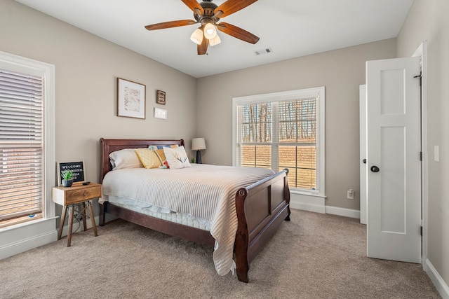 bedroom featuring a ceiling fan, visible vents, light carpet, and baseboards