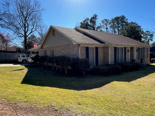 view of property exterior featuring brick siding and a lawn