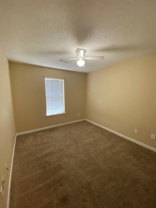 carpeted empty room featuring ceiling fan and a textured ceiling