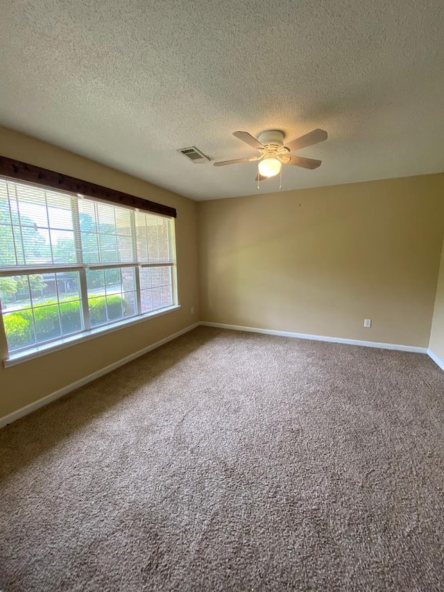 spare room featuring carpet, ceiling fan, and a textured ceiling