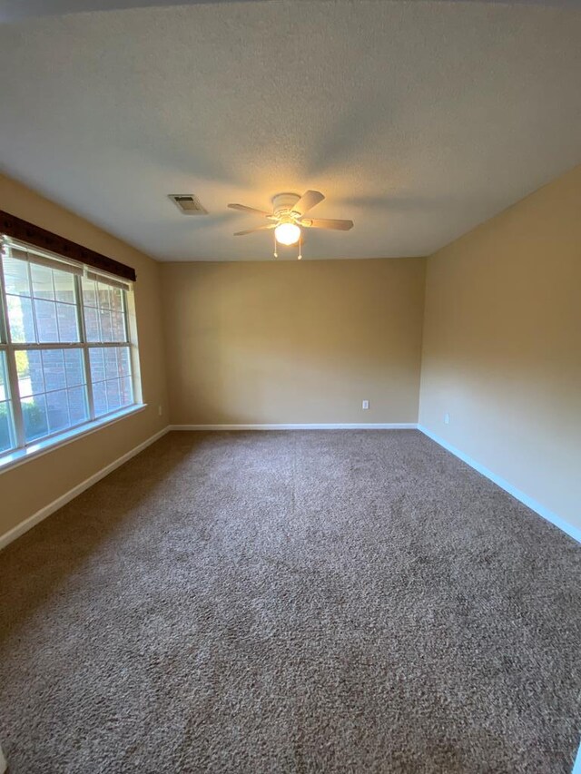 unfurnished room featuring ceiling fan, carpet floors, and a textured ceiling