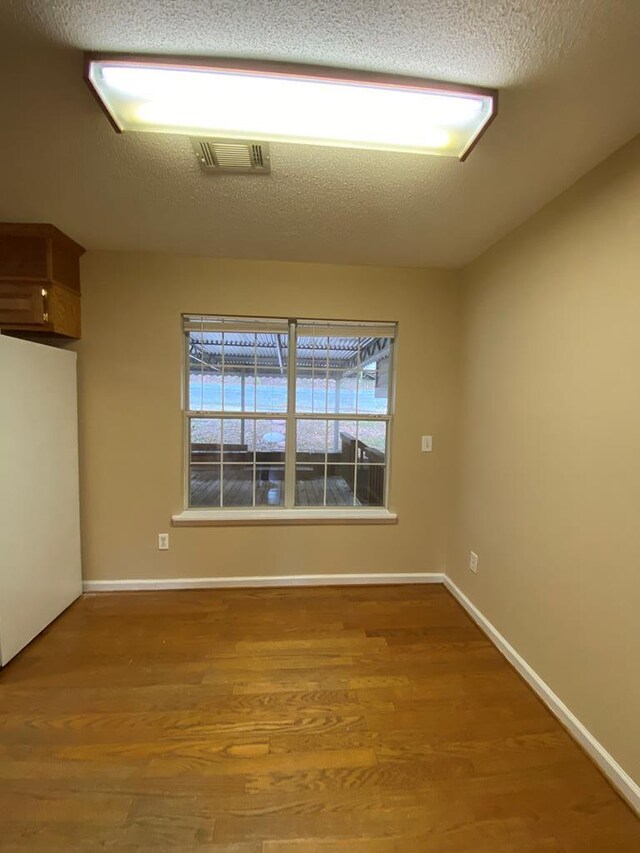 empty room featuring hardwood / wood-style floors and a textured ceiling