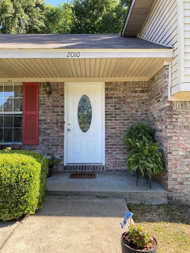 view of exterior entry featuring covered porch