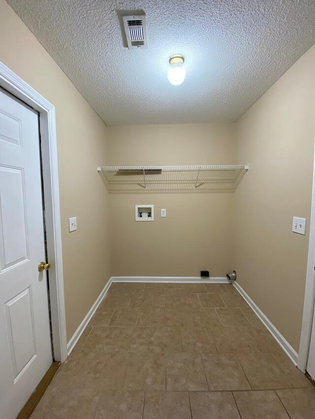 clothes washing area featuring washer hookup, a textured ceiling, and tile patterned floors