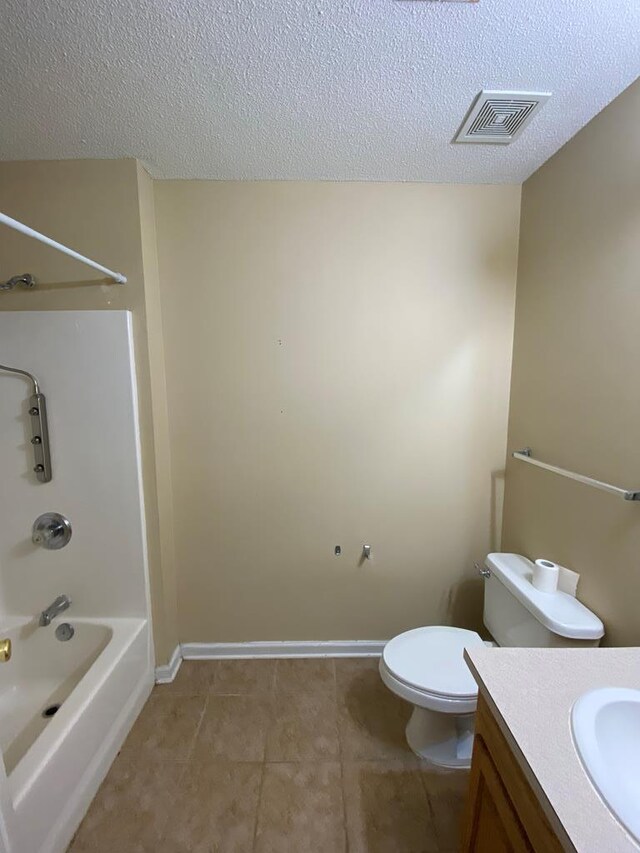 full bathroom featuring tile patterned flooring, tub / shower combination, a textured ceiling, toilet, and vanity