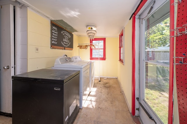 washroom featuring washing machine and dryer and baseboards