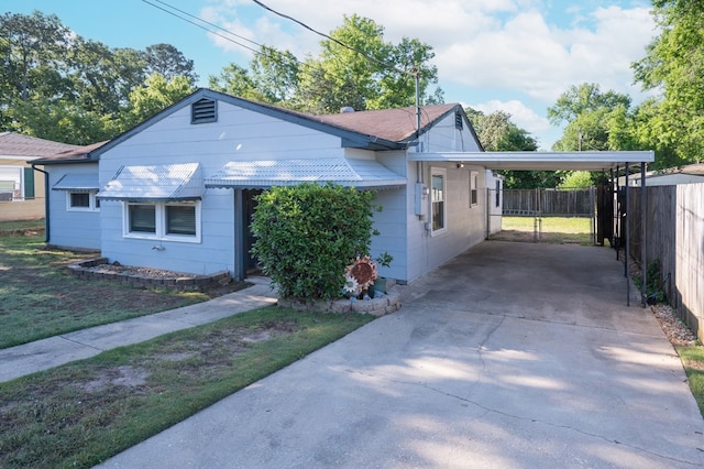 view of front of home featuring fence, driveway, and a carport