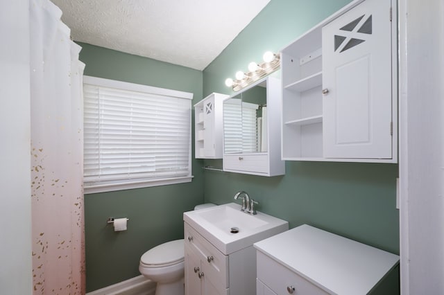 full bathroom with toilet, vanity, and a textured ceiling
