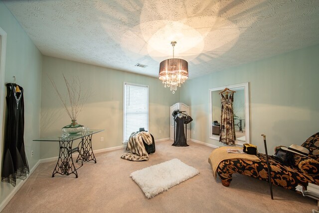 sitting room with a textured ceiling, light colored carpet, and a chandelier