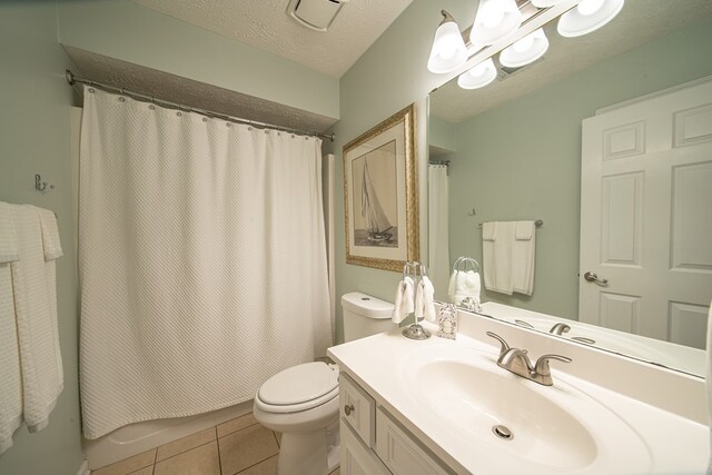 bathroom featuring tile patterned flooring, vanity, walk in shower, toilet, and a textured ceiling