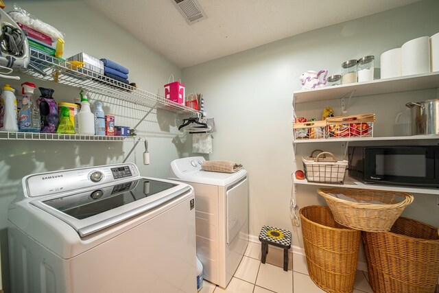 washroom with light tile patterned flooring and washer and dryer