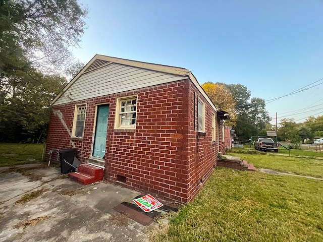 view of home's exterior with a patio area and a lawn