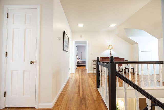 hall featuring wood-type flooring and lofted ceiling