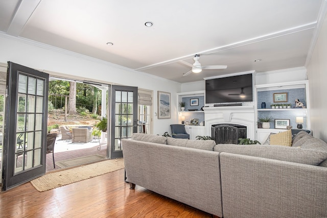 living room with ceiling fan, wood-type flooring, and crown molding