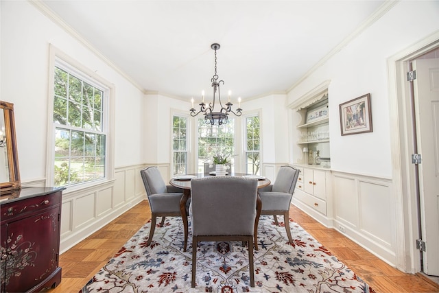 dining room featuring plenty of natural light, ornamental molding, light parquet flooring, and a chandelier