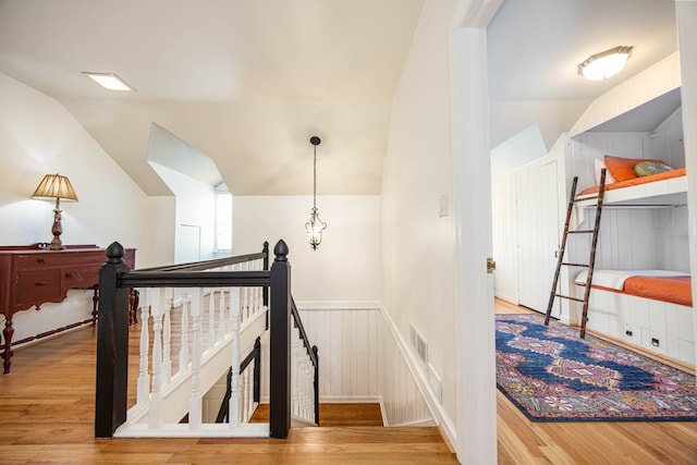 stairs featuring lofted ceiling and hardwood / wood-style floors