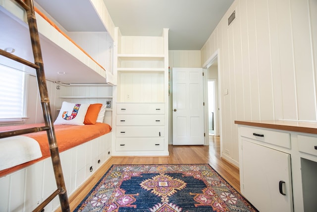 bedroom featuring wood walls and light wood-type flooring