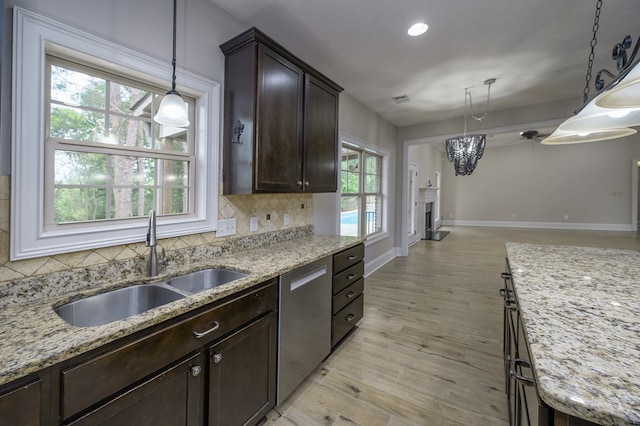 2708 Sawgrass Ln, Phenix City, AL 36867 - kitchen featuring dark brown cabinetry, backsplash, dishwasher, a sink, and baseboards