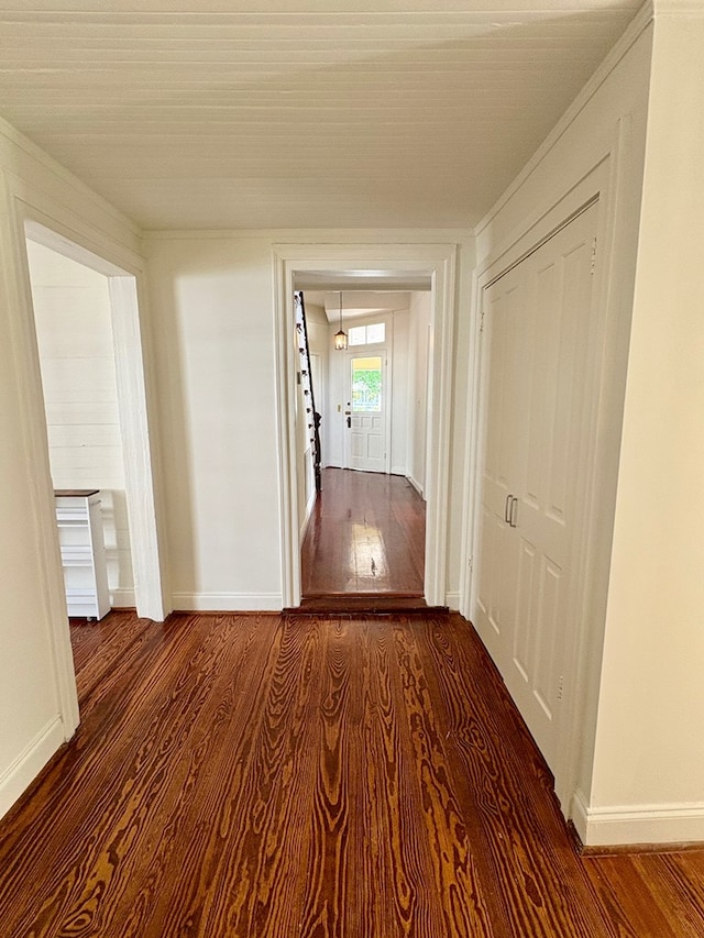 hall with baseboards and wood finished floors