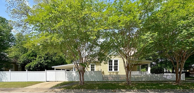 view of property exterior featuring a lawn, driveway, and a fenced front yard