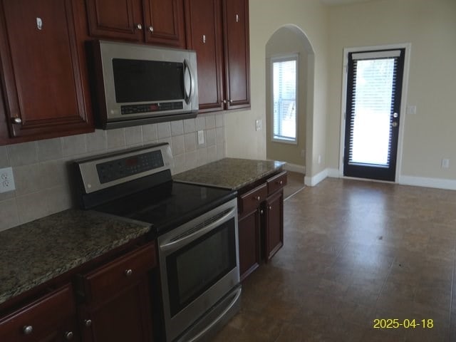 8 Rusty Dr, Phenix City, AL 36869 - kitchen with baseboards, stainless steel appliances, arched walkways, and dark floors