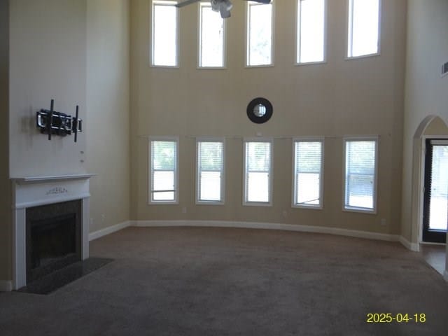 8 Rusty Dr, Phenix City, AL 36869 - unfurnished living room with carpet floors, baseboards, visible vents, a high ceiling, and a fireplace with flush hearth
