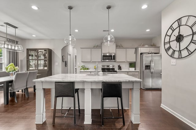 221 Abberly Ln, Ellerslie, GA 31807 - kitchen featuring stainless steel appliances, recessed lighting, a breakfast bar area, a kitchen island with sink, and dark wood-style floors
