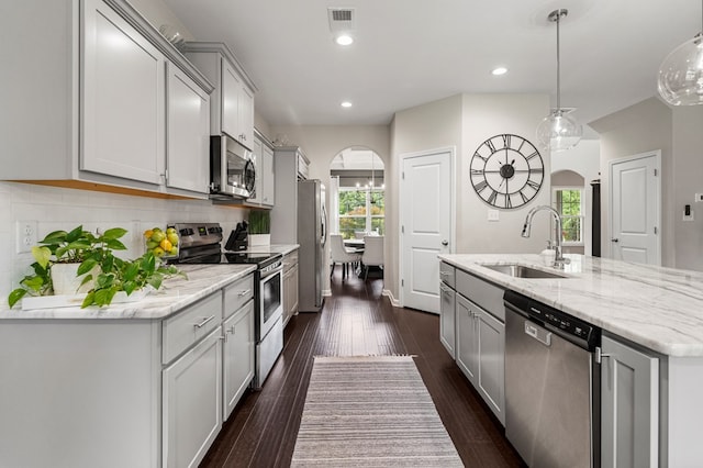 221 Abberly Ln, Ellerslie, GA 31807 - kitchen with appliances with stainless steel finishes, arched walkways, a center island with sink, tasteful backsplash, and dark wood finished floors