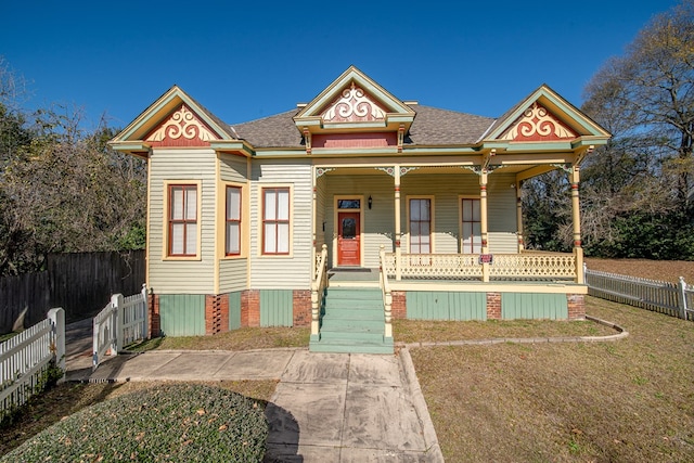 victorian-style house with covered porch and a front lawn