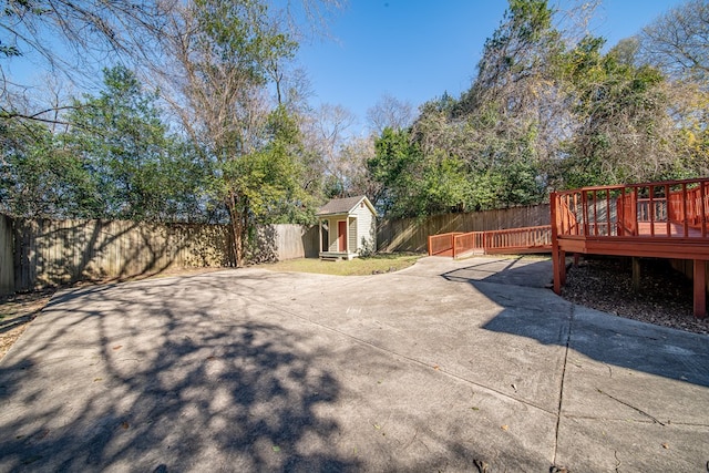 view of patio featuring a wooden deck and a shed