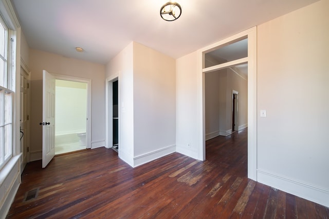 unfurnished bedroom featuring dark wood-type flooring and a closet