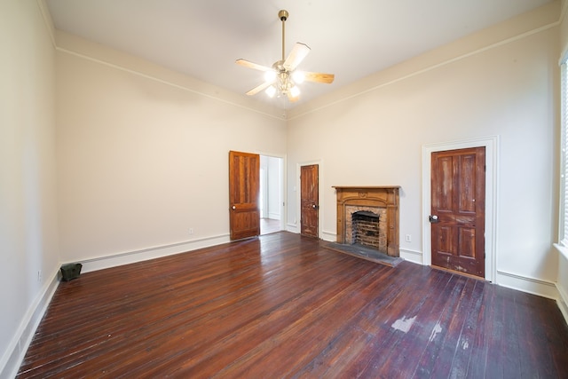 unfurnished living room featuring dark hardwood / wood-style flooring, ceiling fan, and a high ceiling