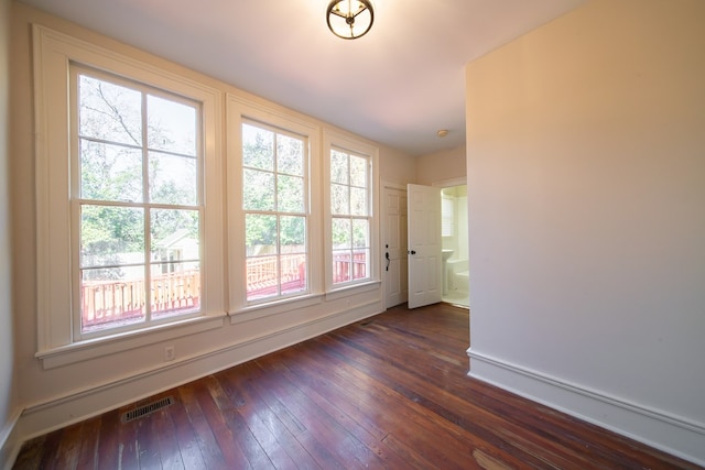 unfurnished room with dark wood-type flooring