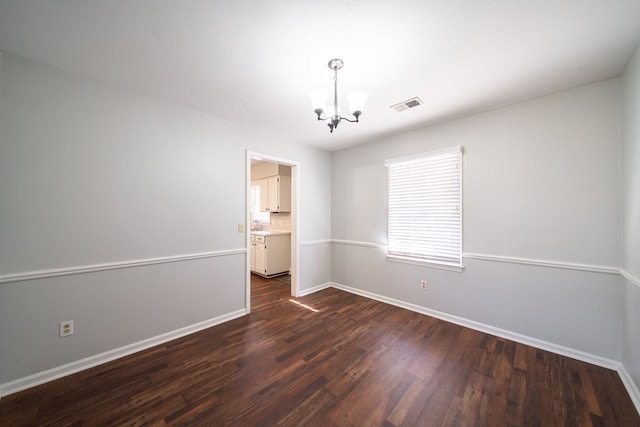 unfurnished room with an inviting chandelier, dark hardwood / wood-style floors, and sink