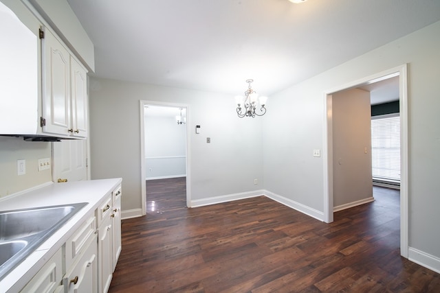 kitchen with white cabinetry, dark hardwood / wood-style floors, decorative light fixtures, and sink